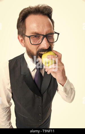 Geschäftsmann klassische formale Kleidung und Brillen halten essen Apple. Gesunde Ernährung Tipps Vision aus den Augen. Besten Lebensmittel für die Gesundheit der Augen. Auge Gesundheit Konzept. Stockfoto