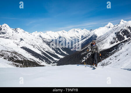 Skifahrer wandern über Roger's Pass und dem Trans-Canada Highway im Glacier National Park, Kanada. Er nähert sich dem Asulkan Hütte (nicht in Aussicht) unter Jungen Stockfoto