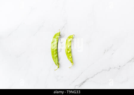Frische Erbsen liegen auf weißem Hintergrund. Flach. Essen Konzept. Ansicht von oben, Overhead, Platz für Text, gesunde Ernährung Stockfoto