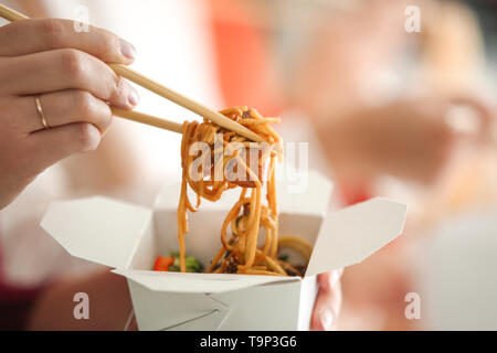 Frau essen chinesische Nudeln von Takeaway, Nahaufnahme Stockfoto