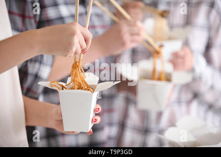 Menschen essen chinesische Nudeln von Takeaway Boxen, Nahaufnahme Stockfoto