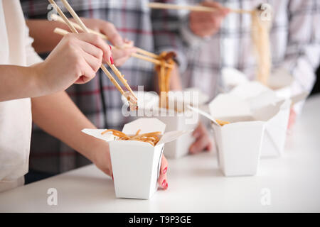 Menschen essen chinesische Nudeln von Takeaway Boxen, Nahaufnahme Stockfoto