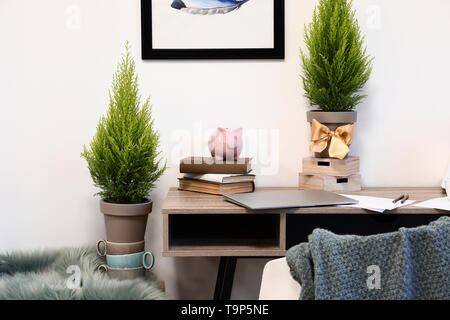 Töpfe mit Zitrone Zypressen im Zimmer mit komfortablen Arbeitsplatz Stockfoto