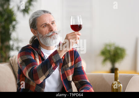 Älterer mann Wein trinken zu Hause Stockfoto