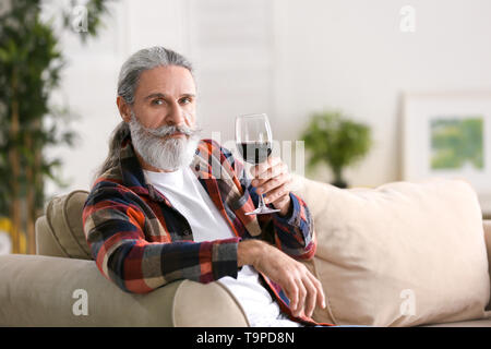 Älterer mann Wein trinken zu Hause Stockfoto