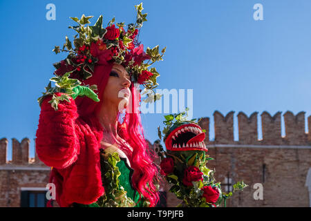 Porträt einer Feminine maskierte Person in einem schönen kreativen Kostüm, in den Gebäuden der Arsenale posiert, feiert die Venezianischen Karneval Stockfoto