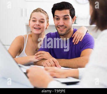 Glückliches junges Paar treffen Finanzberater für Investitionen zu Hause Stockfoto