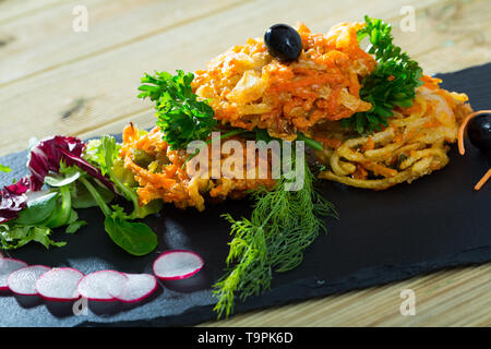 Gebratenes Gemüse in Teig von Tempura Mehl garniert mit cornsalad und Salatblätter, Petersilie, Dill und geschnittene rote Radieschen Stockfoto