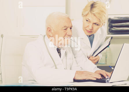 Männlicher Arzt und Krankenschwester in produktiven Tag im Büro Stockfoto