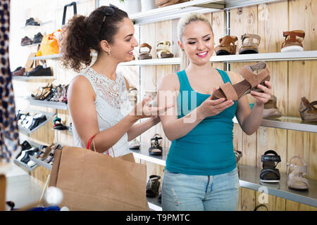 Zwei lächelnde Schöne nette Mädchen hält ein Papier Einkaufstüten in der Boutique Stockfoto