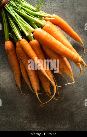 Nantes Karotten auf rustikalen dunklen Hintergrund. Frische organische Superfood Gesund Essen Konzept und Diabetes zu kontrollieren. Stockfoto