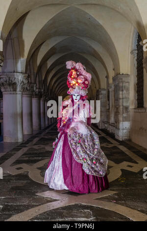 Porträt einer Feminine maskierte Person in einem schönen kreativen Kostüm, in den Arkaden des Dogenpalastes, Palazzo Ducale posing Stockfoto