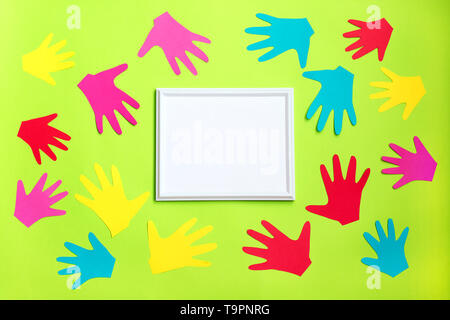Autismus. Schnitt aus farbigem Papier Kinder Palmen rund um weiße Rahmen auf grünem Hintergrund. Welt Autismus Bewußtsein Tag, April Autismus ßtsein Monat Stockfoto