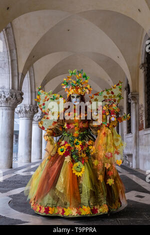 Porträt einer Feminine maskierte Person in einem schönen kreativen Kostüm, in den Arkaden des Dogenpalastes, Palazzo Ducale posing Stockfoto