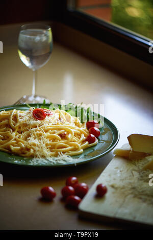 Pasta Carbonara mit geriebenem Parmesan und Cherry Tomaten, dekoriert mit Rucola. italienischen Mittagessen. Stockfoto