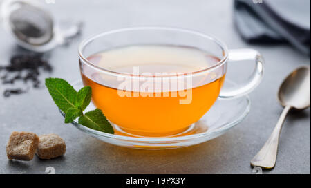 Tasse Tee mit Minze Blatt. Grauer Hintergrund. Close Up. Stockfoto