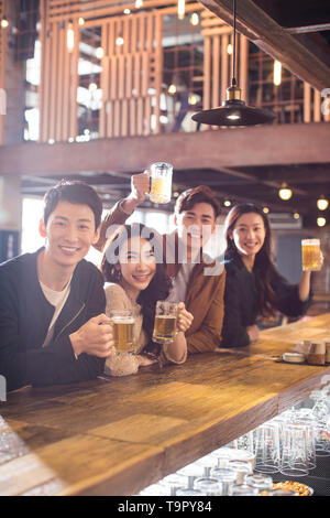 Gerne Freunden Bier trinken und Toasten in bar Stockfoto