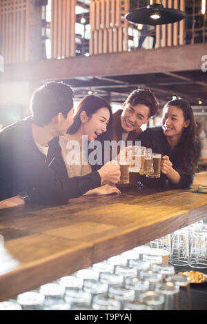 Gerne Freunden Bier trinken und Toasten in bar Stockfoto