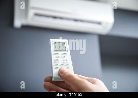 Männliche hand mit Klimaanlage Fernbedienung Stockfoto