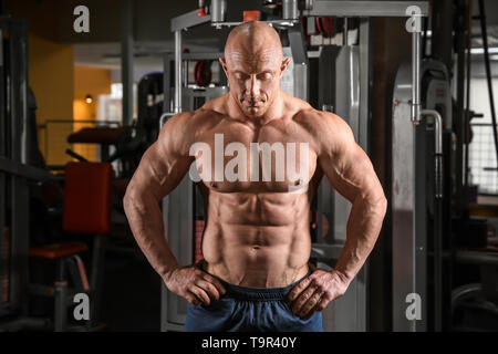 Muskulöser Mann posiert in Fitness-Studio Stockfoto
