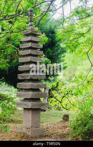 Japanische Granit gartenlaterne von einem schönen Garten umgeben Stockfoto