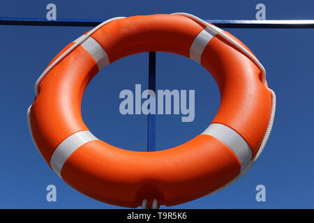 Orange Rettungsring auf einem Schiff. Sicherheit auf dem Wasser, Rettung, leben Ring am blauen Himmel Hintergrund Stockfoto