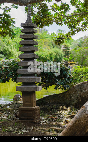 Japanische Granit gartenlaterne von einem schönen Garten umgeben Stockfoto