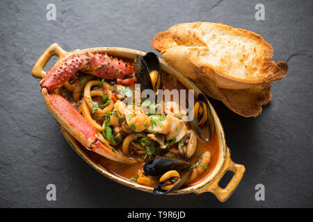 Eine selbstgemachte Version von cioppino Fisch Eintopf. Es ist von squid Ringe aus einem Loligo Kalmaren im Englischen Kanal, Pollack, pollachiu gefangen vulgaris gemacht Stockfoto