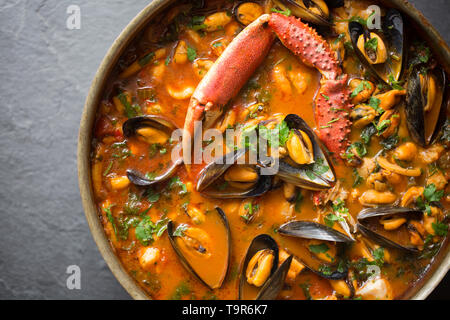 Eine selbstgemachte Version von cioppino Fisch Eintopf. Es ist von squid Ringe aus einem Loligo Kalmaren im Englischen Kanal, Pollack, pollachiu gefangen vulgaris gemacht Stockfoto