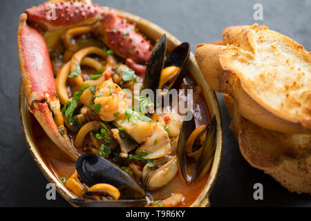 Eine selbstgemachte Version von cioppino Fisch Eintopf. Es ist von squid Ringe aus einem Loligo Kalmaren im Englischen Kanal, Pollack, pollachiu gefangen vulgaris gemacht Stockfoto