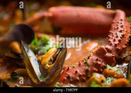 Eine selbstgemachte Version von cioppino Fisch Eintopf. Es ist von squid Ringe aus einem Loligo Kalmaren im Englischen Kanal, Pollack, pollachiu gefangen vulgaris gemacht Stockfoto