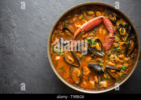 Eine selbstgemachte Version von cioppino Fisch Eintopf. Es ist von squid Ringe aus einem Loligo Kalmaren im Englischen Kanal, Pollack, pollachiu gefangen vulgaris gemacht Stockfoto