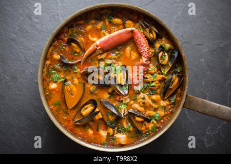 Eine selbstgemachte Version von cioppino Fisch Eintopf. Es ist von squid Ringe aus einem Loligo Kalmaren im Englischen Kanal, Pollack, pollachiu gefangen vulgaris gemacht Stockfoto