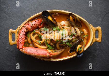 Eine selbstgemachte Version von cioppino Fisch Eintopf. Es ist von squid Ringe aus einem Loligo Kalmaren im Englischen Kanal, Pollack, pollachiu gefangen vulgaris gemacht Stockfoto