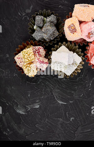 Satz von verschiedenen Turkish Delight om schwarzen Hintergrund. Ansicht von oben. Flach im Nahen und Mittleren Osten Dessert. Stockfoto