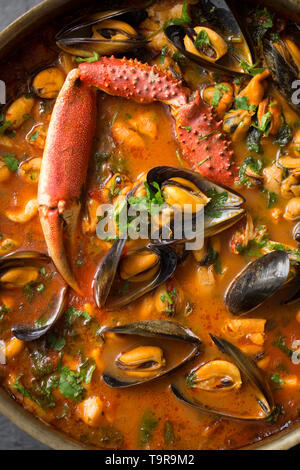 Eine selbstgemachte Version von cioppino Fisch Eintopf. Es ist von squid Ringe aus einem Loligo Kalmaren im Englischen Kanal, Pollack, pollachiu gefangen vulgaris gemacht Stockfoto