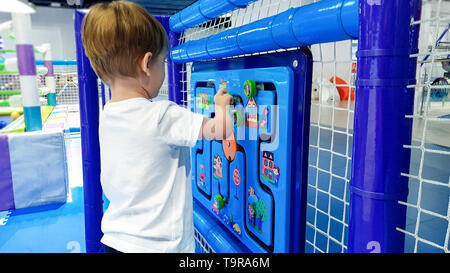 Closeup Bild des kleinen Toddler boy Lösung Puzzle auf der Kinder palyground an Amusement Park. Konzept des smart kids und clevere neue Generation Stockfoto