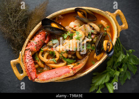 Eine selbstgemachte Version von cioppino Fisch Eintopf. Es ist von squid Ringe aus einem Loligo Kalmaren im Englischen Kanal, Pollack, pollachiu gefangen vulgaris gemacht Stockfoto