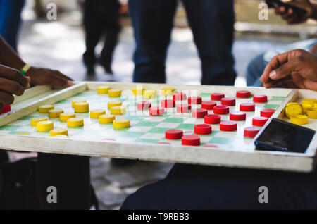 Mann spielt chinese checkers in den Straßen Stockfoto