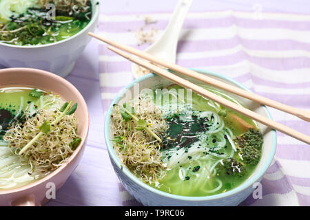 Leckere chinesische Suppe in Schüsseln auf hölzernen Tisch Stockfoto