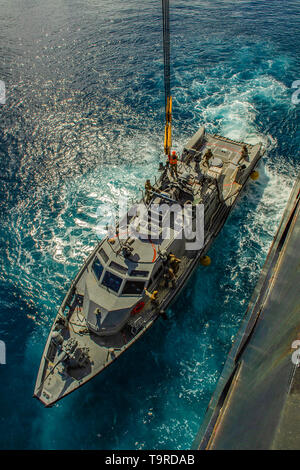 190517-N-TP 834-1052 Santa Rita, Guam (17 Mai 2019) ein Mark VI patrol Boot von der Küste Riverine Squadron (CRS) 2, an die in den Küstenzonen Riverine Group (CRG) 1, Det zugeordnet. Guam, Manöver in Position neben dem Militärischen Sealift Command maritime Vorpositionierung kraft Container, Roll-on/Roll-off und mobile Landeplattform USNS Dahl (T-AKR 312) in Apra Harbor, Guam, während ein Aufzug mit Marine Cargo Handling Bataillon (NCHB) (1), Trennung Guam. CRS-2, an die in den Küstenzonen Riverine Gruppe 1, Det zugeordnet. Guam, ist in der Lage, leitende Maritime Security Operations in das gesamte Spektrum der Naval, joi Stockfoto