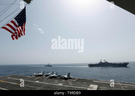 190517-N-MM 912-1058 Arabische Meer (17. Mai 2019) Die Wasp-Klasse amphibisches Schiff USS Kearsarge (LHD3) und der Arleigh-burke-Klasse geführte Anti-raketen-Zerstörer USS Bainbridge (DDG96) Segeln neben der Nimitz-Klasse Flugzeugträger USS Abraham Lincoln (CVN 72). Die Abraham Lincoln Carrier Strike Group (ABECSG) und Kearsarge Amphibious Ready Gruppe (KSGARG) sind die Durchführung von gemeinsamen Aktionen in den USA 5 Flotte Bereich der Operationen. Die ABECSG und KSGARG, mit der 22 Marine Expeditionary Unit, bereit sind, auf unvorhergesehene Ereignisse zu reagieren und US-Kräfte und Interessen in der Region zu verteidigen. (Uns Na Stockfoto