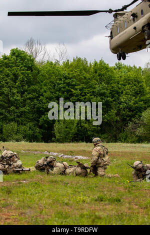 Fallschirmjäger vom 1.BATAILLON, 503Rd Fallschirm Infanterie Regiment (PIR), 173Rd Infantry Brigade Combat Team (Airborne) ziehen die Sicherheit als CH-47 Chinook Hubschrauber zurück zu ihrer ursprünglichen Position in Udbina Airbase, Kroatien fliegen, mehr Soldaten zurück zum Truppenübungsplatz Eugen Kvaternik Slunj, Kroatien, 18. Mai 2019 zu bringen. IR19 ist ein traditionell slowenischen und kroatischen Streitkräften led-Übung, die vor kurzem in Größe und Umfang zugenommen hat. (U.S. Armee Foto von Pvt. Laurie Ellen Schubert, 5 Mobile Public Affairs Abteilung) Stockfoto