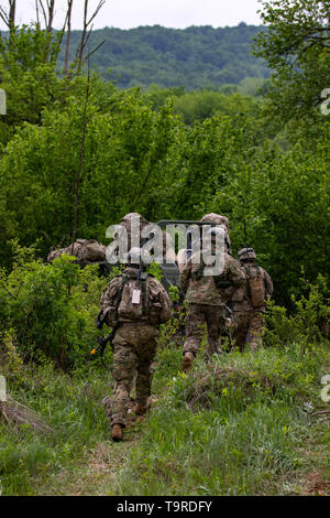 Ein Team von Fallschirmjägern vom 1.BATAILLON, 503Rd Fallschirm Infanterie Regiment (PIR), 173Rd Infantry Brigade Combat Team (Airborne) zu Fuß in die Baumgrenze führte durch eine Armee Boden Mobilität Fahrzeug während der Übung sofortige Reaktion19 am Truppenübungsplatz Eugen Kvaternik Slunj, Kroatien, 18. Mai 2019. Us-Streitkräfte regelmäßig trainieren mit Verbündeten und Partnern, sich weiterhin zu engagieren, posierten und bereit mit glaubwürdigen Kräfte zu gewährleisten, Abschreckung und in einer immer komplexeren Umwelt Sicherheit verteidigen. (U.S. Armee Foto von Pvt. Laurie Ellen Schubert, 5 Mobile Public Affairs Abteilung) Stockfoto