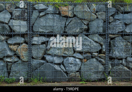 Landschaft Stein Stützmauer in Metall net Stockfoto