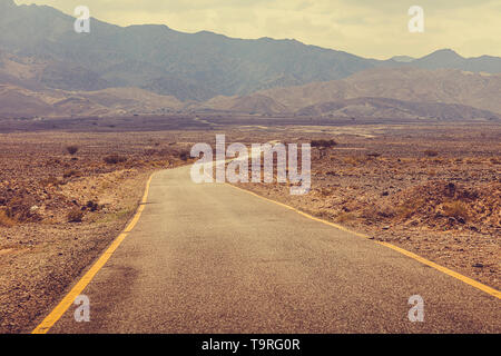 Wüste Straße nach Wadi Rum, Jordanien. Die Berge im Hintergrund. Stockfoto