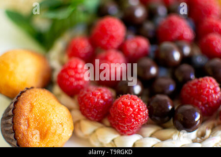 Frühstück mit Muffins und Brombeeren und roten Beeren. Beginnen Sie den Tag mit Energie. Essen beim Aufstehen Stockfoto