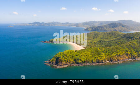 Luftaufnahme Insel mit tropischen Sandstrand und Palmen. Malajon Island, Philippinen, Palawan. touristischen Boote an der Küste tropischen Insel. Sommer und Reisen Urlaub. Strand und blaues Meer Wasser Stockfoto