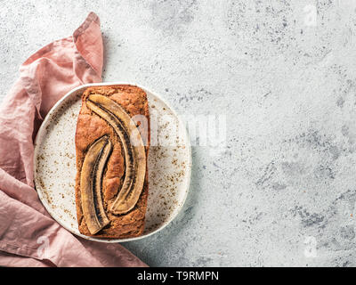 Butter, Zucker-freien Bananenbrot mit Hafermehl, weiche Quark und Honig. Blick von Oben auf die volle Banane Brot für das Handwerk die Platte über der grauen Hintergrund. Platz kopieren. Ideen und Rezepte für gesunde Ernährung Frühstück Stockfoto