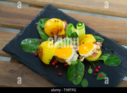 Mini Burger mit Kartoffeln, Speck, Wachteleier und Grüns Stockfoto